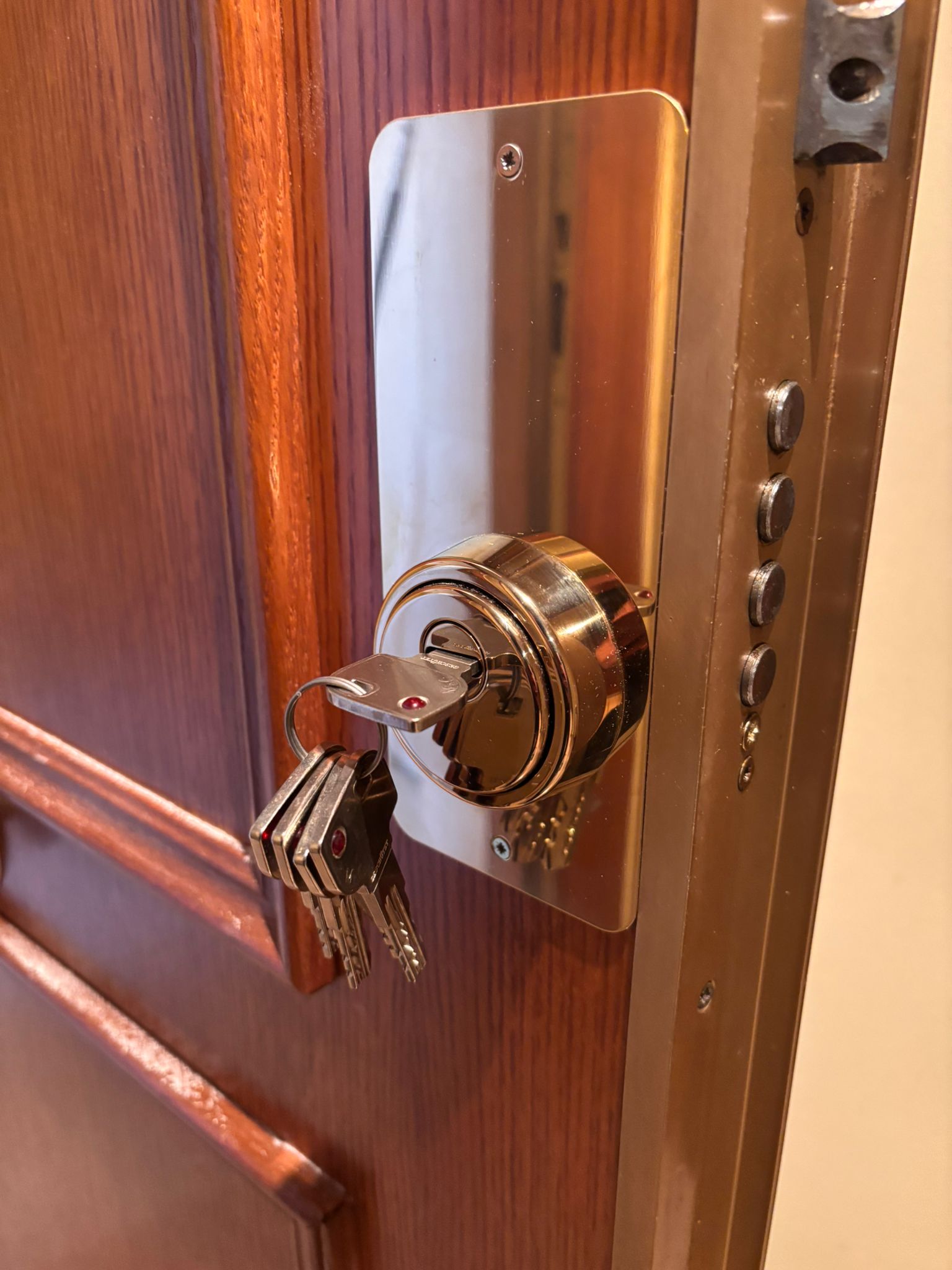 Bombín de seguridad con llaves insertado en puerta acorazada